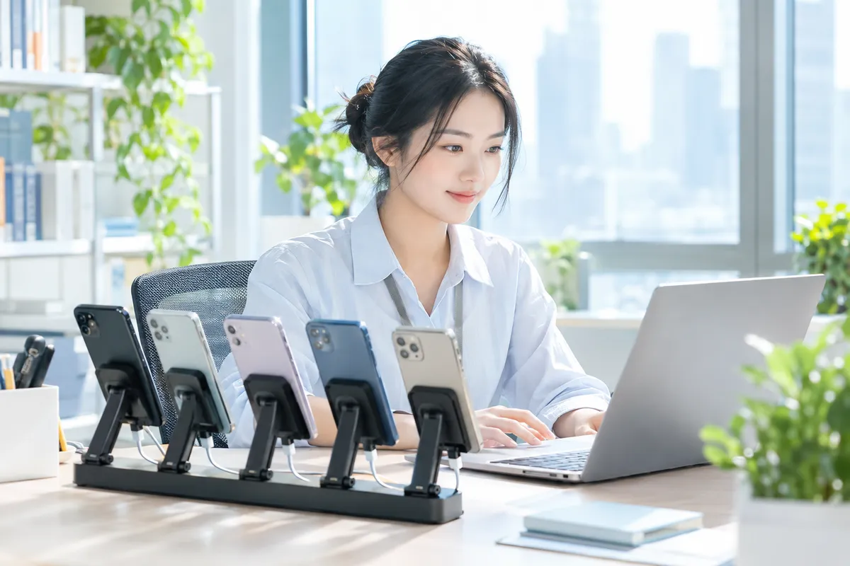 运营专员用支架上的多部手机与电脑管理客户会话